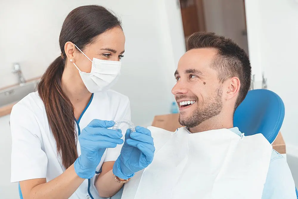 orthodontist from Wink Orthodontics in Prosper, TX showing Invisalign clear aligners to her patient