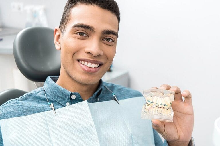 a man holdoinog a dental model after understanding how long do braces take in austin, tx