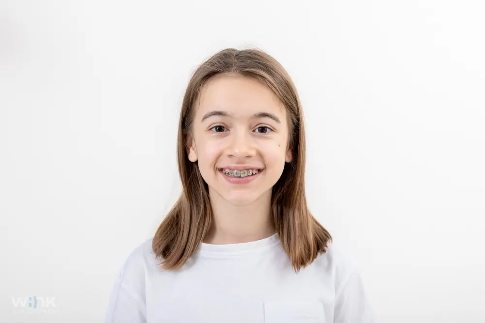 Portrait of a happy young girl with braces smiling highlighting braces for overbite in prosper and colleyville, tx