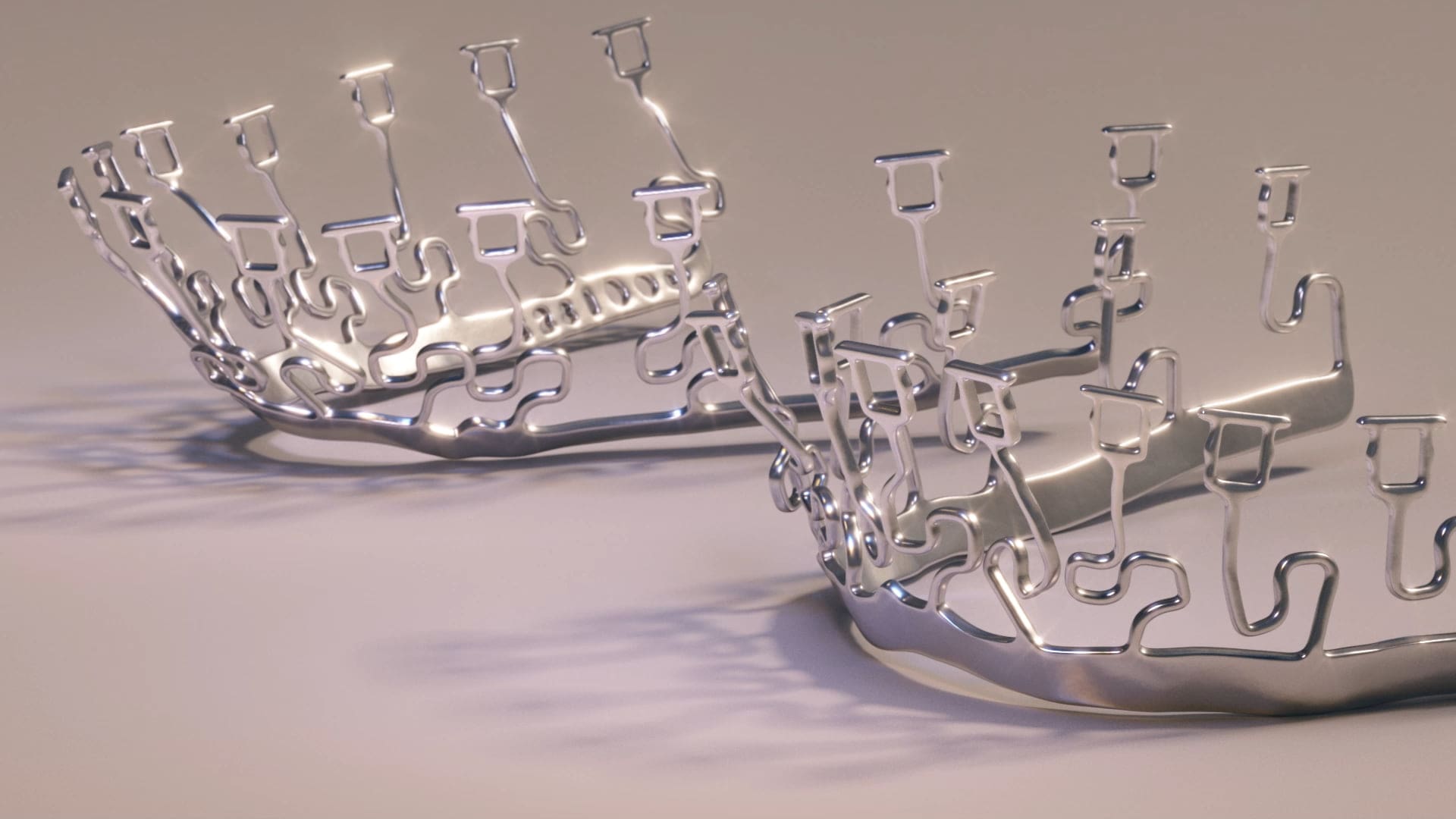 Metallic crowns with abstract designs rest on a smooth surface, reflecting Wink Orthodontics' innovation in Prosper or Colleyville, TX.