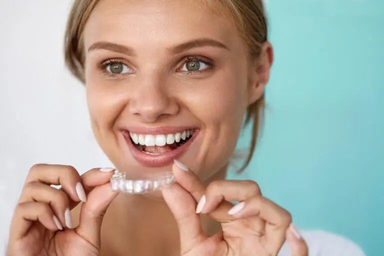 smiling woman with beautiful smile using invisalign clear aligners - How Does Invisalign Work in Prosper, TX