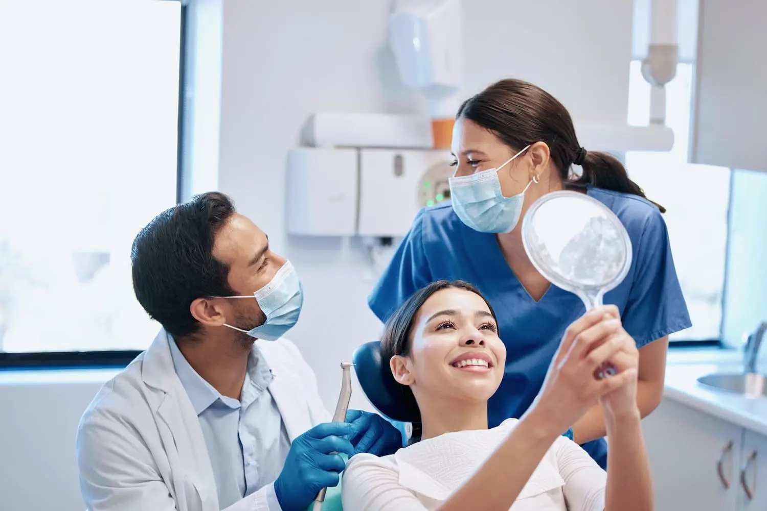 an Orthodontist in Colleyville, TX and an assistant looking at each other after examining patients teeth